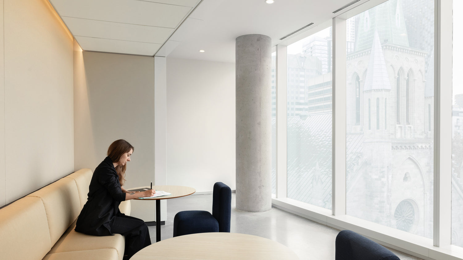Personne prenant des notes dans un espace de travail collaboratif de l’édifice Hélène-Desmarais.